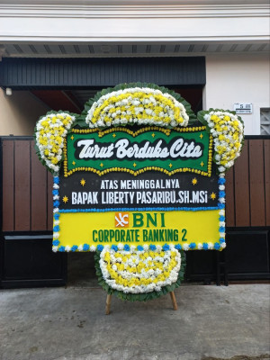 Papan Bunga Duka di Belakang Balok