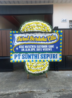 Papan Bunga Duka di Belakang Balok