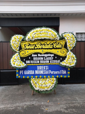 Papan Bunga Duka di Belakang Balok