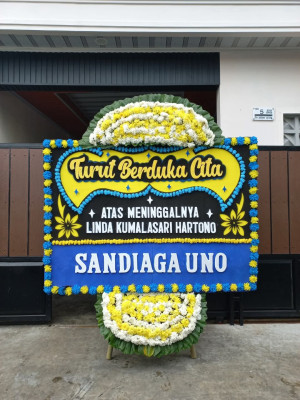 Papan Bunga Duka di Belakang Balok
