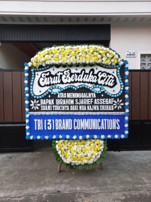 Papan Bunga Duka di Belakang Balok